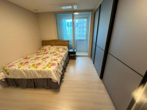 a small bedroom with a bed and a window at Byeollae Station I-park Suite Apartment 16F in Namyangju