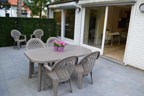 a table and chairs with flowers on a patio at B&B Lobelia-Brugge in Bruges