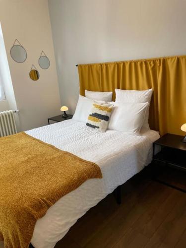 une chambre avec un grand lit avec des draps et des oreillers blancs dans l'établissement Les jardins de marlioz appartement 3 chambres et parkings, à Aix-les-Bains