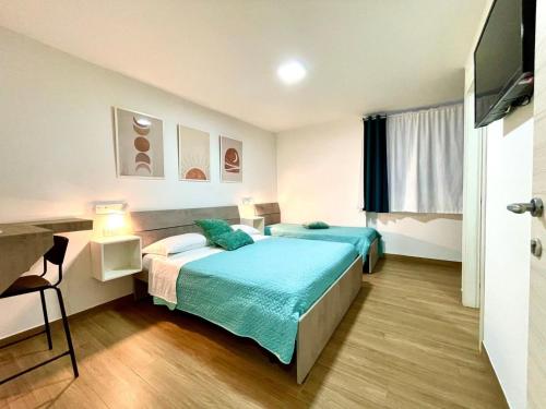 a hotel room with two beds and a flat screen tv at MaryGrace B&B in Castellammare di Stabia