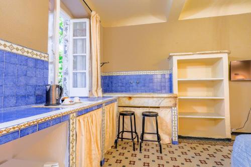 a kitchen with two bar stools in front of a counter at White Lerici in Lerici