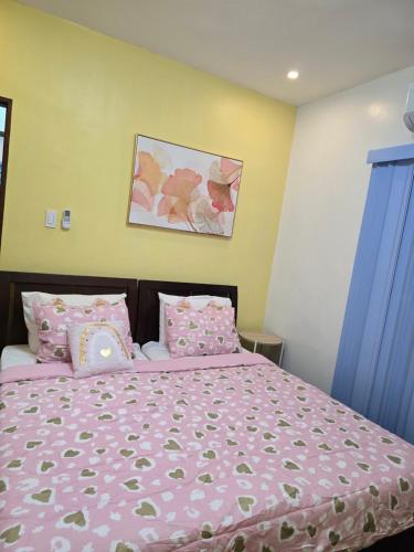 a bedroom with a bed with pink sheets and pillows at Home in Bacolod in Bacolod