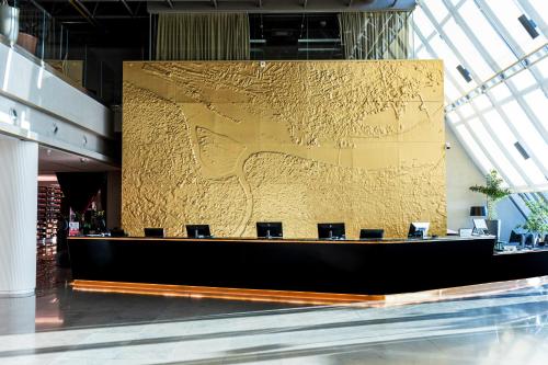 a gold wall in a lobby with chairs at Crowne Plaza Belgrade by IHG in Belgrade