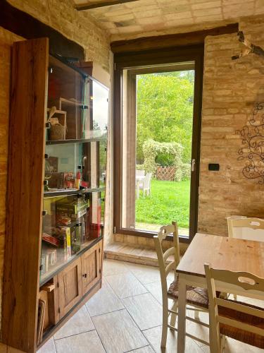 a dining room with a table and a large window at Tenuta Gran Bosco in Loro Piceno
