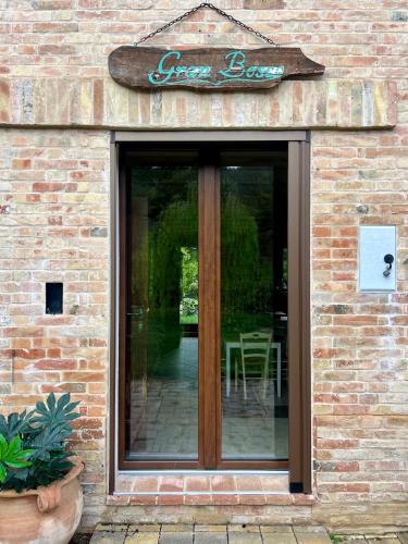 a glass door on a brick building with a sign at Tenuta Gran Bosco in Loro Piceno