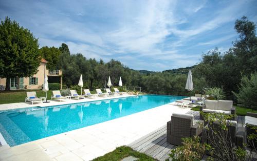 une piscine avec chaises longues et parasols dans l'établissement Grasse Mongibello, à Grasse