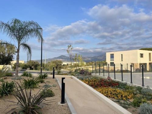 une passerelle dans un parc à côté d'un bâtiment dans l'établissement Grand appartement avec vue mer panoramique, à Calvi