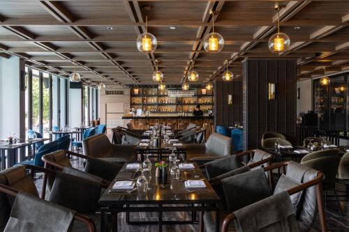 a restaurant with tables and chairs in a room at Ten Six Hundred, Chao Phraya, Bangkok by Preference, managed by The Ascott Limited in Bangkok