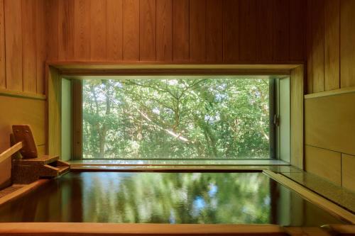 a window in a room with a pool of water at Hotel Grand Bach Atami Crescendo in Atami