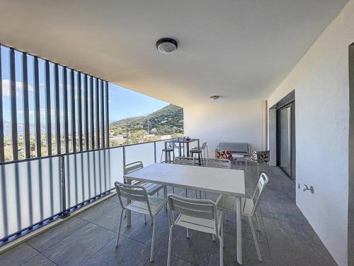 une salle à manger avec une table et des chaises sur un balcon dans l'établissement Grand appartement avec vue mer panoramique, à Calvi