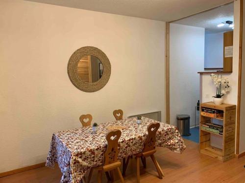 - une salle à manger avec une table, des chaises et un miroir dans l'établissement Appartement cosy hyper-centre Cauterets, à Cauterets