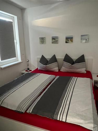 a large bed in a room with a red and white at Hasenwinkel 6 in Gelbensande