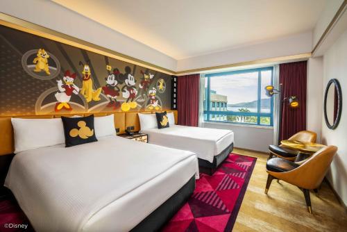 a hotel room with two beds and a window at Disney's Hollywood Hotel in Hong Kong