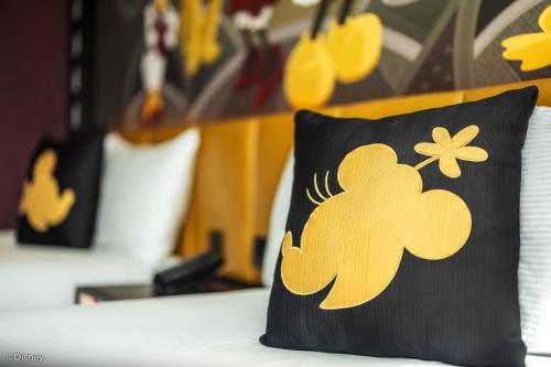 a black pillow with yellow flowers on it on a bed at Disney's Hollywood Hotel in Hong Kong