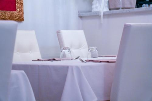 a table with a white table cloth and two glasses at White Lerici in Lerici