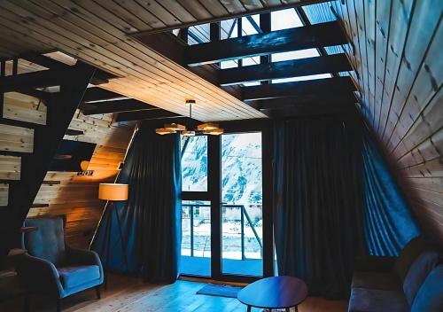 a living room with a chair and a window at Sanseco Cottage in Stepantsminda
