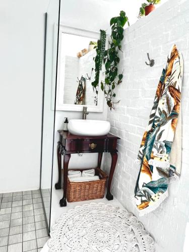a bathroom with a sink and a mirror at Sunny Bali Cottage in Mossel Bay