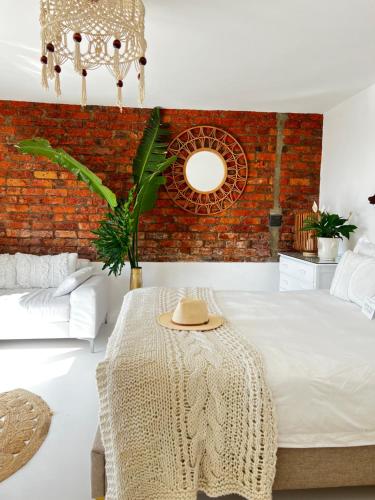 a bedroom with a bed with a table with a hat on it at Sunny Bali Cottage in Mossel Bay