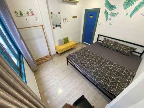 a small bedroom with a bed and a blue door at THE JOYS HOSTEL in Ho Chi Minh City