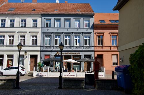 a large building with umbrellas in front of it at Das BilderbuchCafe - Ferien Apartment NO 5 - Markt 7 in Havelberg