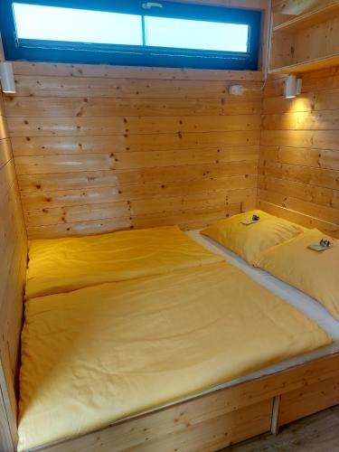 two beds in a wooden cabin with a window at Esperanzahof in Oberndorf an der Melk