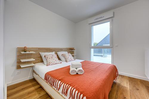 une chambre avec un lit avec deux serviettes dessus dans l'établissement Le Loarwenn - Bel appt avec terrasse et parking, à Vannes