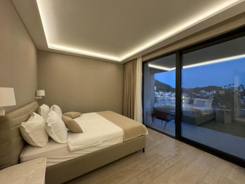 um quarto com uma cama e uma janela grande em Exclusive villa Kaza - Przno em Budva