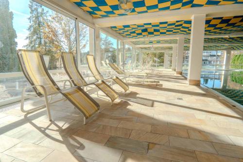a row of chairs sitting on a patio at Ferienwohnung BergOase mit Pool & Sauna in Scheidegg