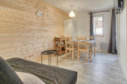 d'une salle à manger avec une table et des murs en bois. dans l'établissement Résidence les Gourgs Blancs - 80m des pistes, à Génos