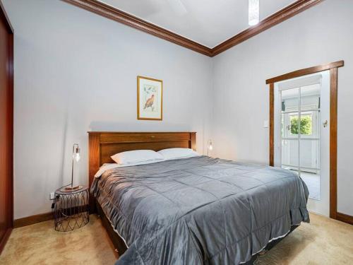 a bedroom with a large bed and a window at Santos 20th century cottage in South Burnie