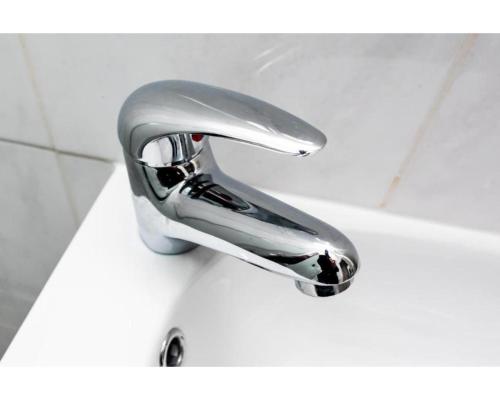 a chrome bathroom faucet on a white sink at Uno Hotel Heathrow Windsor in Slough