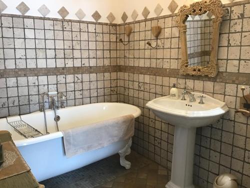 a bathroom with a tub and a sink at Villa fiora chambre in Martigues