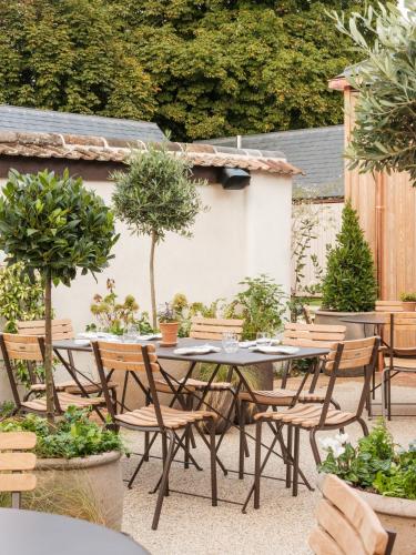 a patio with a table and chairs and trees at The Great Bustard in Durnford