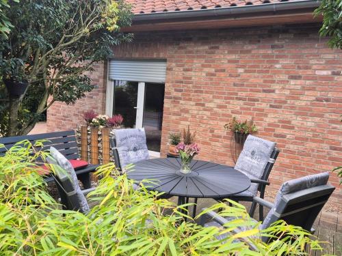 a table and chairs in front of a brick building at fewo-aller-auszeit in Hademstorf