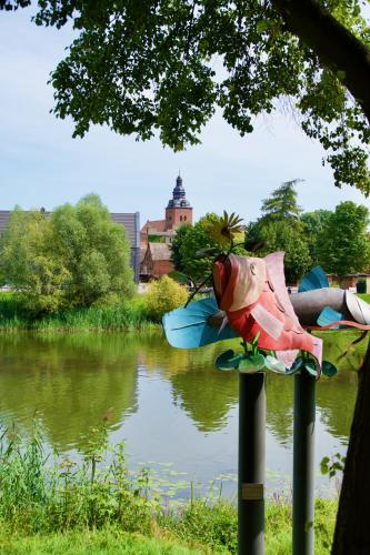 a statue of a fish on a pole next to a river at Das BilderbuchCafe - Ferien Apartment NO 5 - Markt 7 in Havelberg