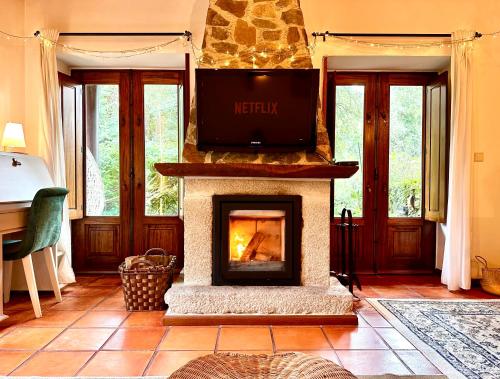 a living room with a fireplace with a tv on top at Villa Esquina 204 - Connected With Nature- uChill in Riba de Âncora