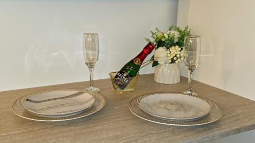 - une table avec des assiettes, des verres et une bouteille de champagne dans l'établissement Paris Sacré Cœur Arev Sur les pas d Emily in Paris, à Paris