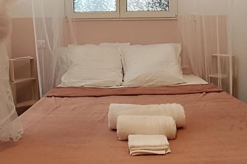 - un lit avec 2 serviettes et une fenêtre dans l'établissement Le petit cocon, à Nevers