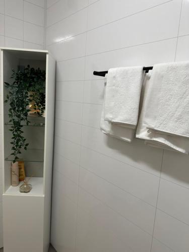 a bathroom with white towels hanging on a wall at Lys rent og trivelig hybelleilighet in Kristiansand