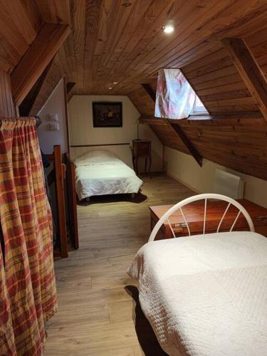 une chambre avec deux lits dans une pièce avec des plafonds en bois dans l'établissement maison 4 personnes face à la mer, à Plouguerneau