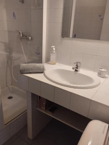 une salle de bain avec un lavabo, des toilettes et un miroir dans l'établissement maison 4 personnes face à la mer, à Plouguerneau