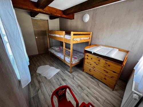 a small room with two bunk beds and a dresser at Am Dàntzwaj in Lembach