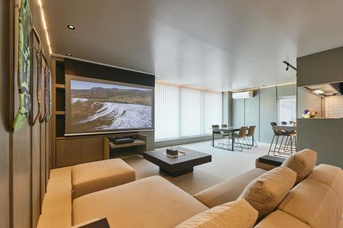 a living room with a couch and a flat screen tv at Nishimachi BASE in Sapporo