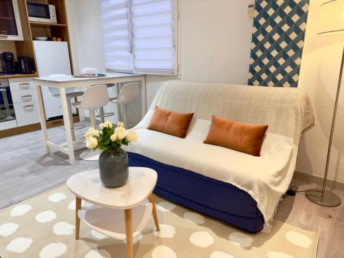 Cette chambre comprend un lit avec un vase de fleurs sur une table. dans l'établissement Grand studio confortable au coeur de Cannes, à Cannes