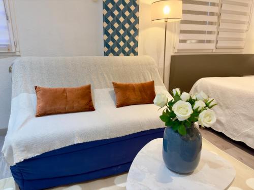 - un salon avec un canapé et un vase de fleurs dans l'établissement Grand studio confortable au coeur de Cannes, à Cannes