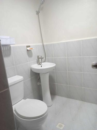 a bathroom with a toilet and a sink at Laugh tale Staycation in Suba