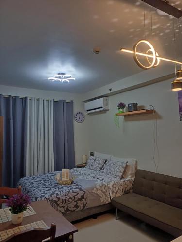 a bedroom with a bed and a couch at Laugh tale Staycation in Suba