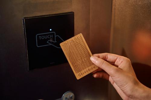 a person holding a book in front of a tv at Hotel Grand Bach Kyoto Select in Kyoto