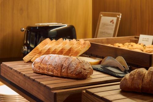 a loaf of bread on a wooden table with breadsticks at Hotel Grand Bach Kyoto Select in Kyoto