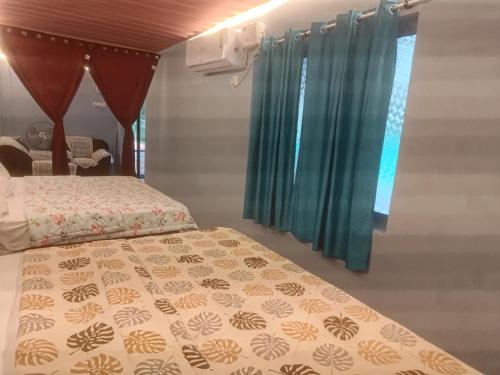a bedroom with two beds and a window at Peaceful Abode in Auroville